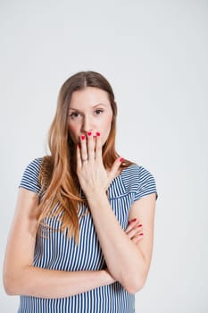 Studio portrait of relaxed attractive and stylish woman covering mouth with hand
