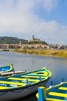 View of the medieval village Gruissan with colorful rowing boats in the foreground