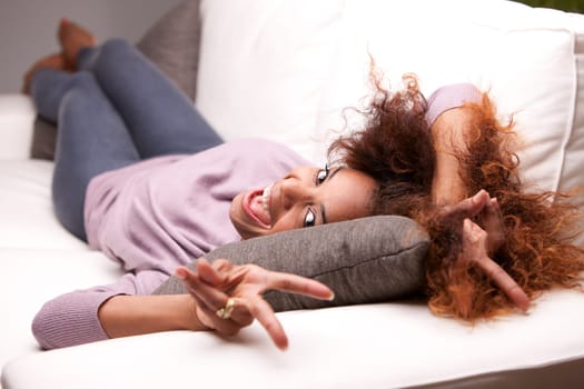 beautiful young black happy woman on a sofa in her living room