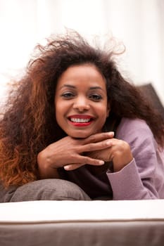 beautiful young black happy woman on a sofa in her living room