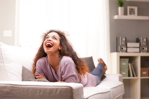 beautiful young black happy woman on a sofa in her living room