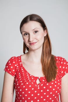 Studio portrait of happy smiling attractive woman wearing spotty red blouse