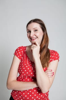 Studio portrait of smiling attractive woman with folded arms and hand on chin