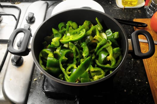 Coocking Green Chili Pepperson a Black Pot