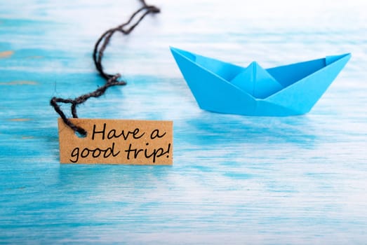 Natural Looking Label with Have a Good Trip on it and a Origami Boat in the Background