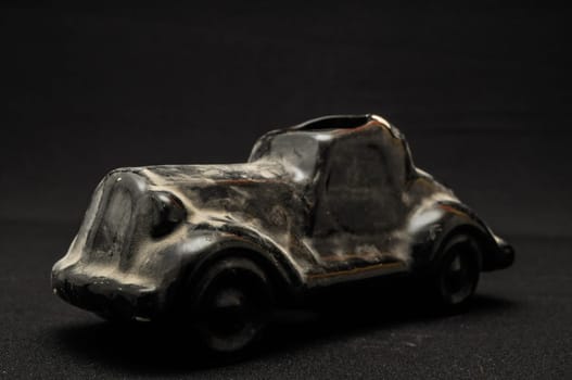 Vintage Old Ceramic Black Car on the Dark background