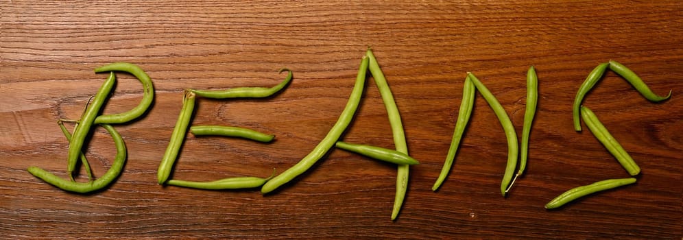 Green beans on a wooden background