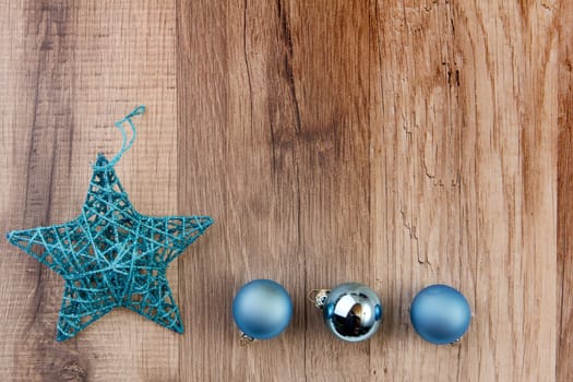 Christmas star and Christmas baubles turquoise on wooden background