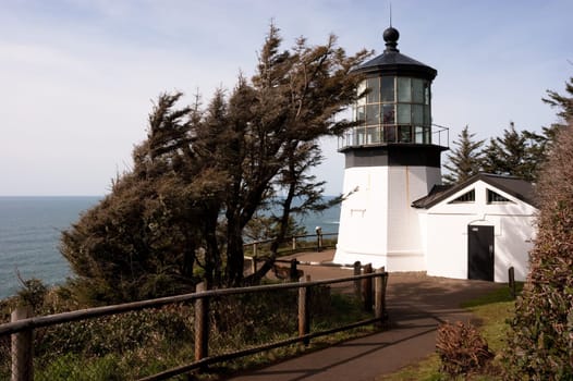 A footpath leads down to the lighthouse on a sunny day