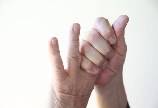 a man grasps the first two fingers of his left hand