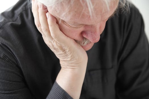 older man slumped in depression or grief