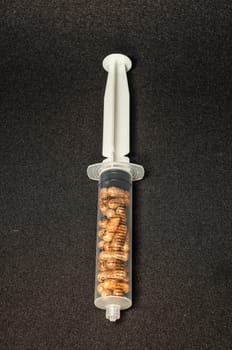 Medical Syringe Full of Pill Drugs on a Black Background