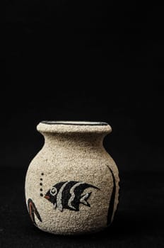 Colorful designed clay vase over a Black background