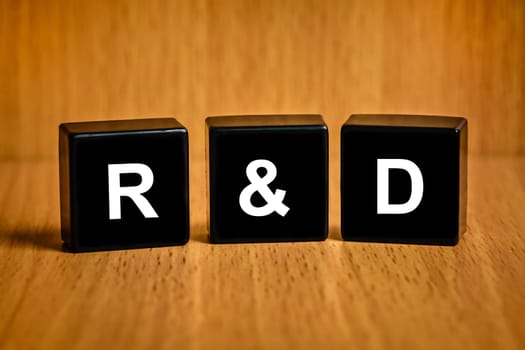 r&d or Research and development text on black block, business concept