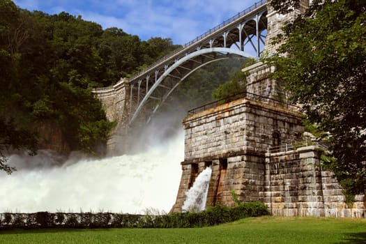 Dam on mountain river. Expanded water from the waterfall.