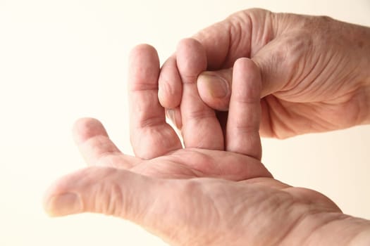 senior man with stiffness or numbness in his finger
