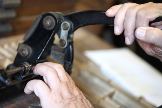 printer using a vintage cutter to trim metal pieces