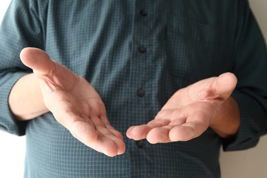 man holds his hands out in a gesture with several meanings