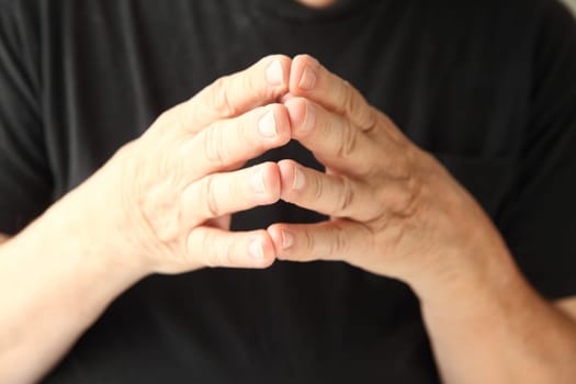 a man holds his fingertips together