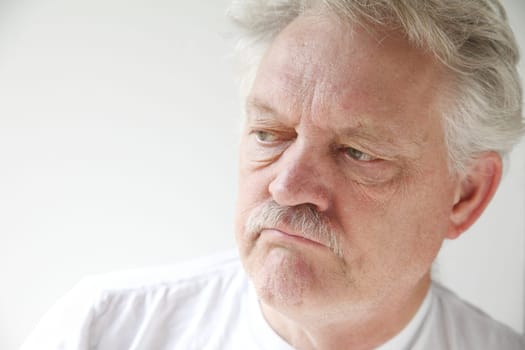 older man with a negative, disgruntled expression