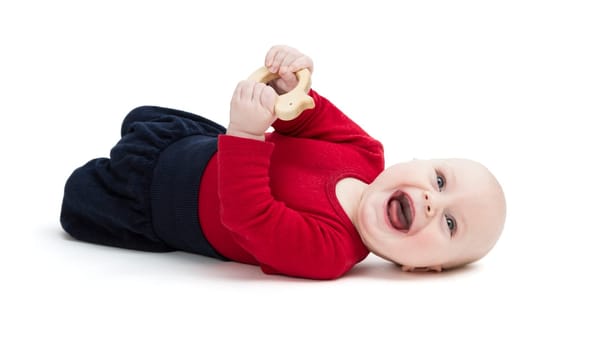 laughing baby in red shirt on floor. isolated on white background