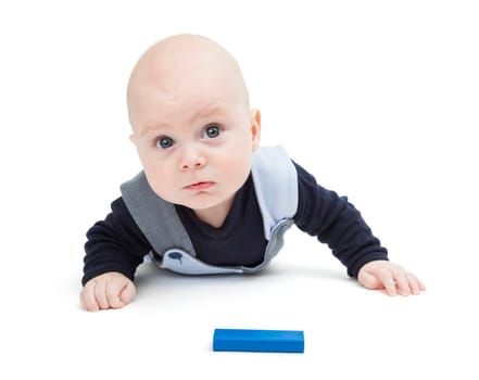interested baby with toy block on floor isolated on white