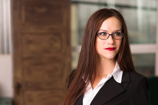 Beautiful young adult woman looks left off camera in the office