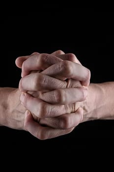 Praying hands on a black background