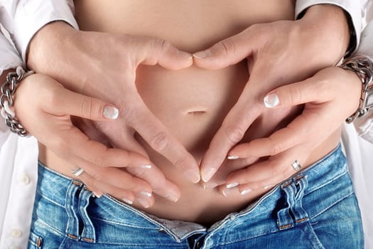 Parents-to-be form heart on baby belly