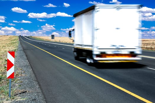 Big transporter truck travelling along the highway at speed