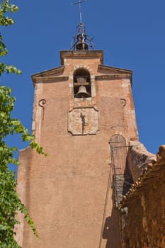 The church clock tower. Orange ocher plaster (Roussillon, Vaucluse, Provence, France)