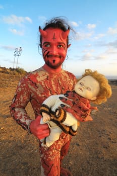 Latin American Man with Long Hairs Masked as a Devil in the Desert