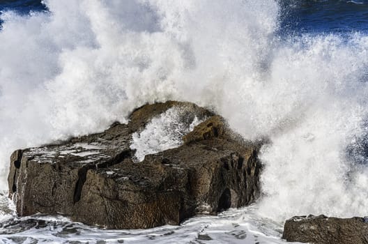 Beautiful splashing wave in to the rocks, with great details and quality. The image is takken in Spain, Getaria city at the Atlantic ocean.