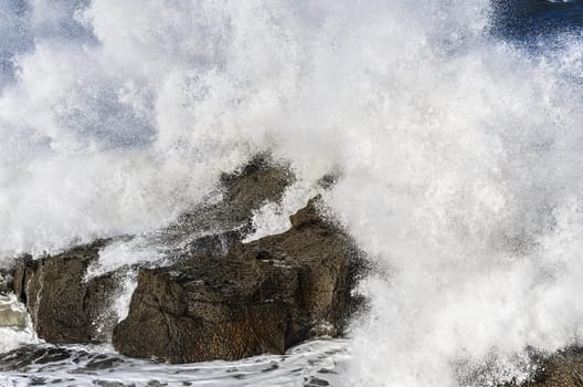 Beautiful splashing wave in to the rocks, with great details and quality. The image is takken in Spain, Getaria city at the Atlantic ocean.