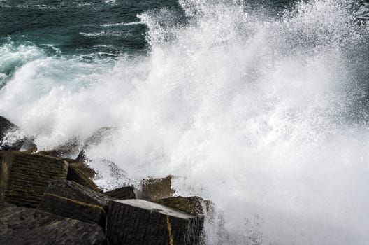 Beautiful splashing wave in to the rocks, with great details and quality. The image is takken in Spain, Getaria city at the Atlantic ocean.