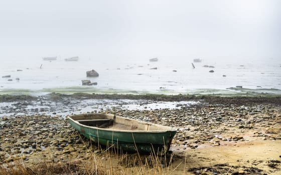 Old fishing boat at coast foggy in the morning