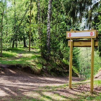 Wooden sign board on the natural trail. In the   forest park
