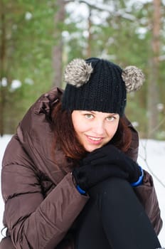 Portrait of the charming young woman in winter outdoors