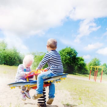 Boy and girl swinging on a swing
