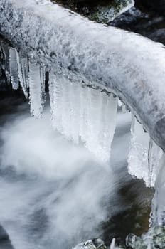 Frozen icicles on water flow,  close-up