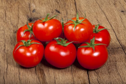 A pile of ripe tomatoes on a wooden table