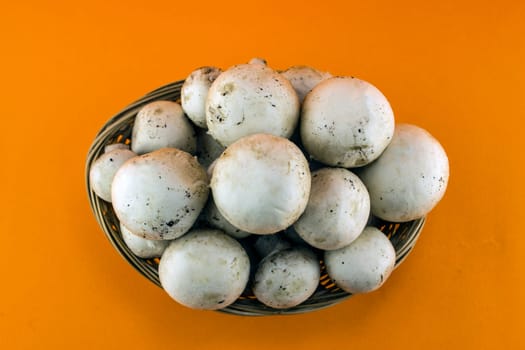 button mushrooms in straw basket, champignons.