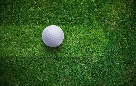 Golf ball on green grass .