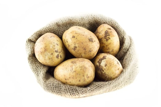 potatoes in burlap sack isolated on white background .