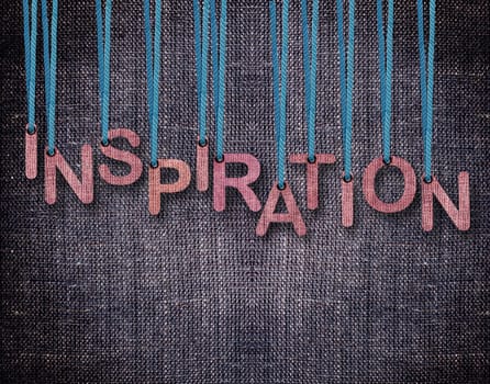 Letters hanging strings with blue sackcloth background.