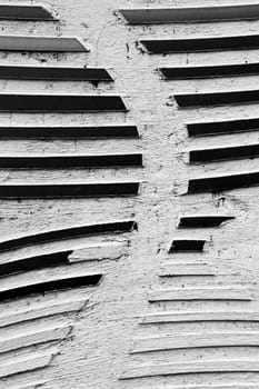 The photograph of a wall with a chipped silver ornament.