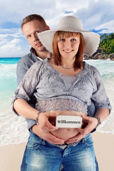young pregnant couple on the beach