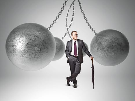 3d image of huge swinging metal ball and businessman