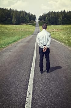 standing senior man and empty long road