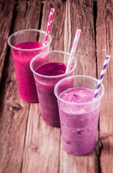 Variety of delicious berry smoothies with strawberry and blueberry blended with low fat yogurt for a healthy summer drink, high angle view standing in a diagonal row